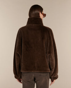 Jean femme en denim marron foncé coupe droite avec une matière en coton légèrement délavée, ajusté à la taille et aux hanches.