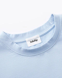 T-shirt en coton bleu clair avec col rond et étiquette Labdip, textile doux et confortable, idéal pour un look casual et estival.