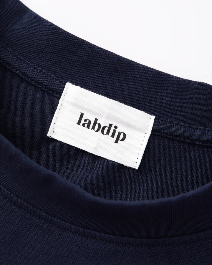 Détail du col rond sur un t-shirt bleu marine en coton doux, avec étiquette de la marque Labdip cousue à l'intérieur.