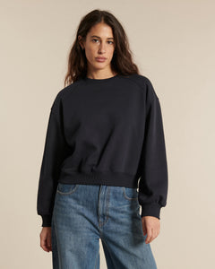 Jean droit bleu denim en coton avec une coupe classique et une taille haute, offrant une silhouette moderne et confortable pour femme.