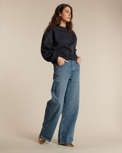 Jean femme en denim bleu clair, coupe droite et large, offrant une silhouette confortable et moderne, confectionné dans un coton épais et de qualité.