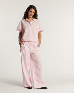 Pantalon en popeline rose clair coupe large et fluide, matière légère en coton adaptée pour l'été, offrant un confort et une silhouette élégante.