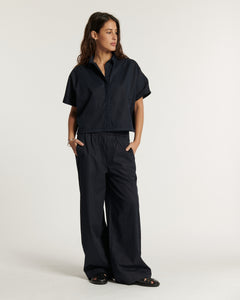 Pantalon large en popeline marine, coupe fluide et confortable, matière légère en coton adaptée pour un style décontracté et élégant au quotidien.