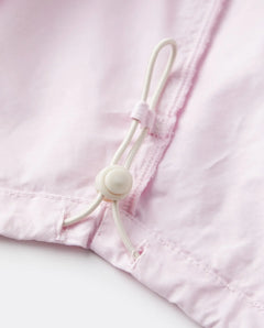 Détail d’un jean femme en popeline rose clair en coton, avec cordon de serrage ajustable pour un confort personnalisé et une coupe adaptable.