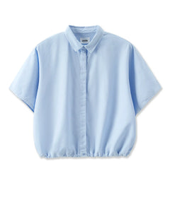 Chemise légère en popeline bleu clair, coupe ample et courte avec manches larges et col classique, tissu doux et fluide idéal pour l'été.
