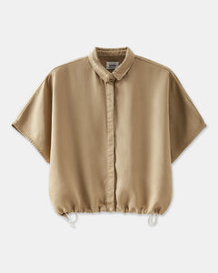 Chemise femme beige en tissu fluide avec coupe ample, col classique et bas resserré par un cordon ajustable.
DEVA chemise