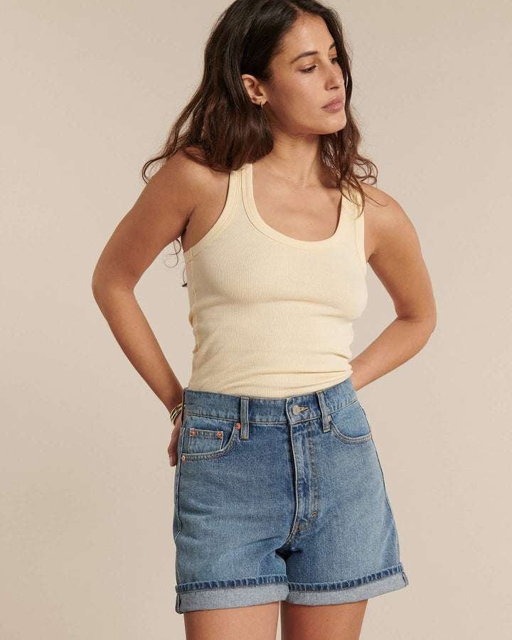 Short en denim bleu clair en coton, coupe droite légèrement ample avec revers, adapté à toutes les morphologies féminines pour un style estival décontracté.