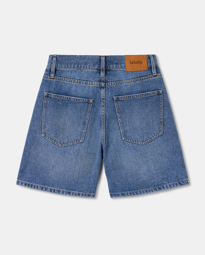 Short denim femme en jean 100% coton de couleur bleu clair, coupe droite, finition classique avec poches arrière et ceinture avec passants.