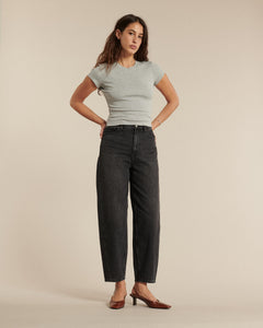 Jean femme en denim noir délavé, coupe droite légèrement large, tissu en coton rigide offrant un maintien parfait et un style moderne adaptable à toutes morphologies.
Porté par le mannequin de face