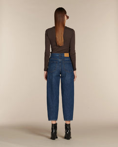 Jean en denim bleu foncé 100 % coton avec coupe ballon, taille haute et poches arrière, adapté aux morphologies en X, V et H, style décontracté et moderne.
Porté par le mannequin de dos