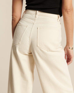 Jean femme en denim écru 100 % coton avec coupe large et taille haute, offrant un ajustement confortable et adapté à toutes les morphologies.
Porté par le mannequin de dos