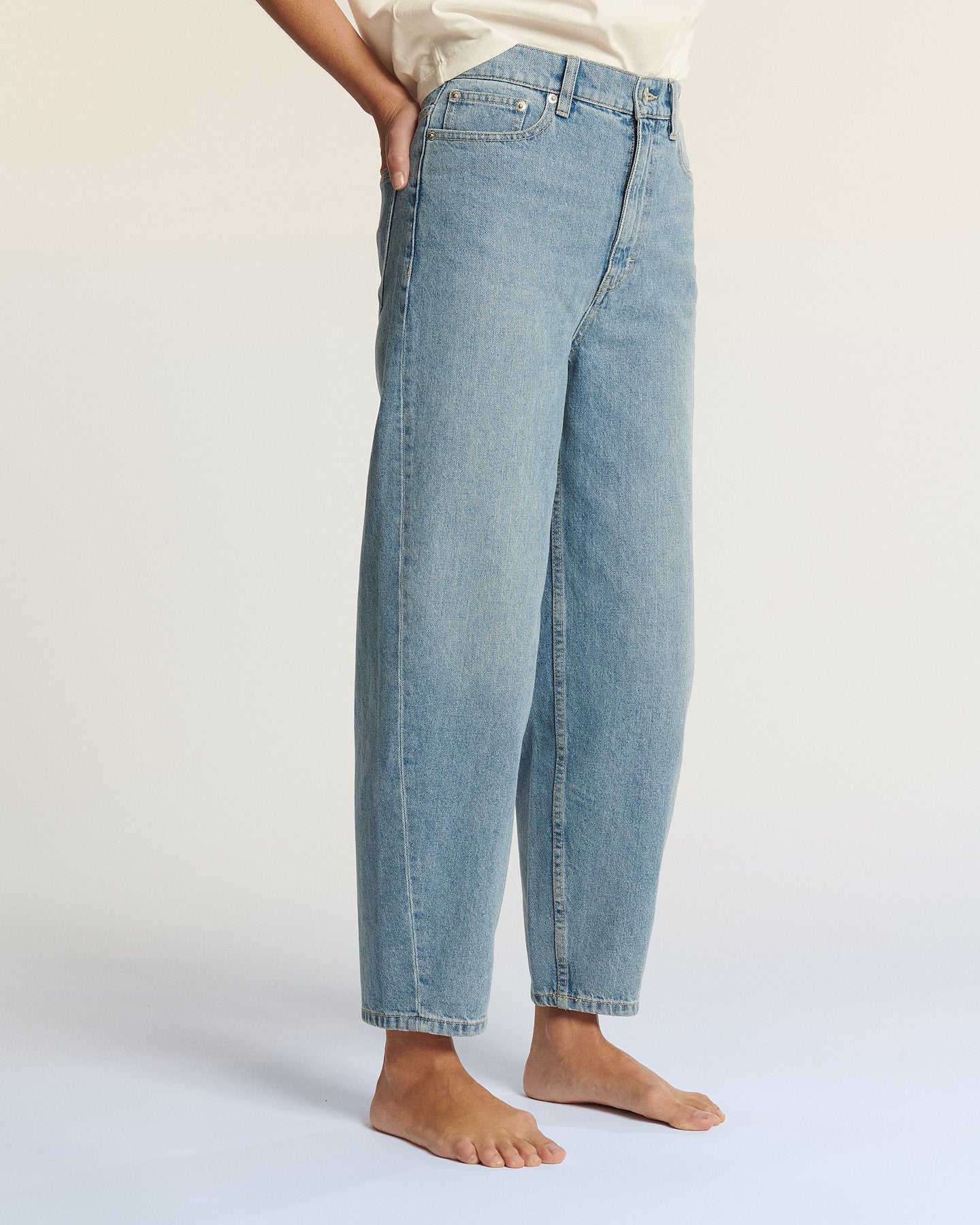 Jean en denim léger bleu clair, coupe droite légèrement ample, 100 % coton, parfait pour un style décontracté et confortable pour femme.
Jean ballon JEMMA en denim bleu clair porté par le mannequin, vue de face, coloris IN 27.