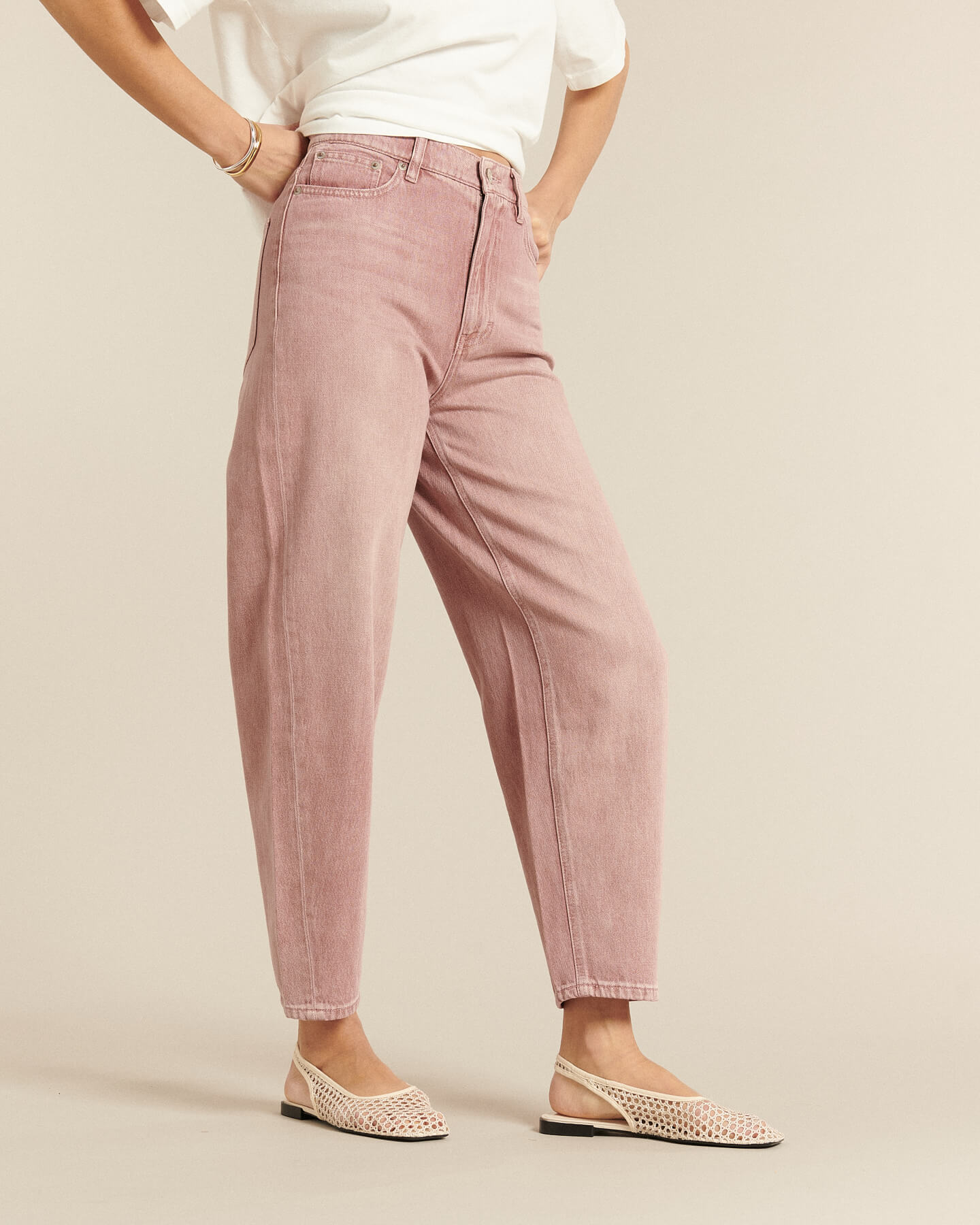 Jean femme en denim de coton rose quartz, coupe ballon légèrement ample, taille haute et finition douce, conçu pour s’adapter à toutes les morphologies.
Porté par le mannequin de face