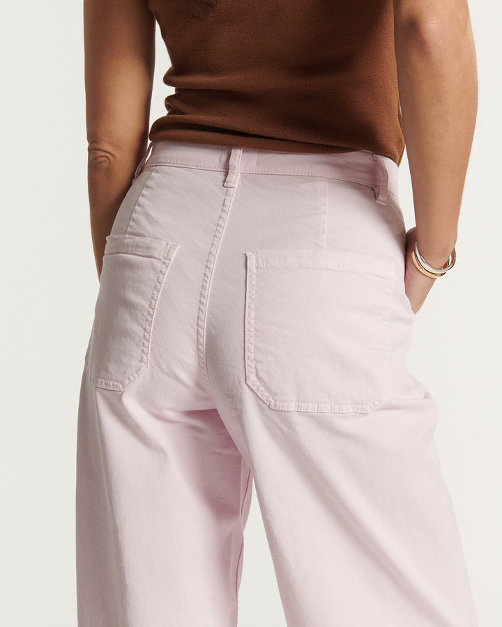 Jean femme en coton de couleur rose pâle avec coupe large et poches arrière carrées offrant un style décontracté et confortable.