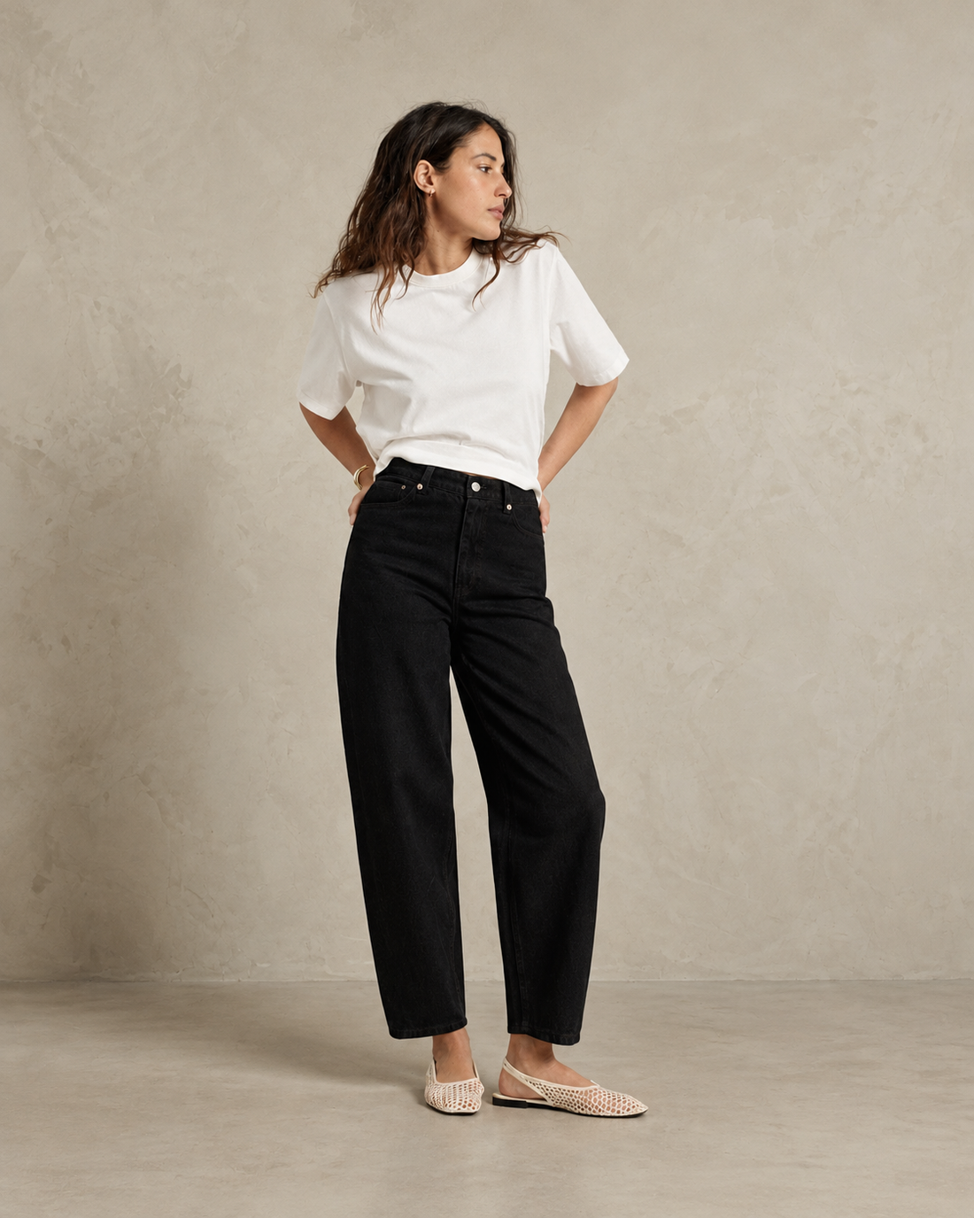 Jean pour femme en denim noir, coupe droite et ample, taille haute, texture coton, offrant une silhouette fluide et confortable.