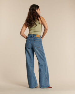 Jean femme en denim bleu clair 100 % coton, coupe large et droite, offrant un tombé fluide et un confort adapté à toutes les morphologies.
Porté par le mannequin de dos