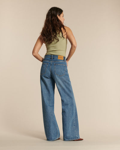 Jean femme en denim bleu clair 100 % coton, coupe large et droite, offrant un tombé fluide et un confort adapté à toutes les morphologies.
Porté par le mannequin de dos