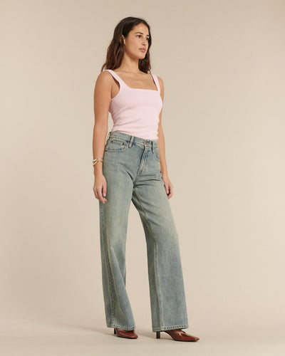 Jean femme en denim bleu délavé, coupe large et droite, matière 100 % coton, offrant un tombé fluide et un confort adapté à toutes les morphologies.
Porté par le mannequin de face
