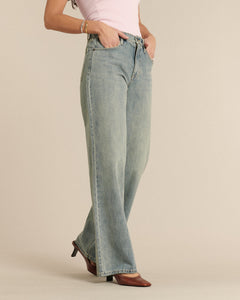 Jean femme en denim bleu délavé clair, coupe flare ample et confortable, en coton 100% doux pour un style estival et élégant.
Porté par le mannequin de face