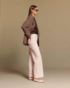 Jean flare en denim couleur rose vintage clair, confectionné en coton, avec une coupe large et fluide idéale pour les morphologies en X, alliant élégance et confort.
porté par le mannequin de profil