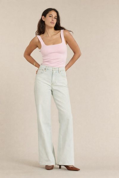 Jean femme en denim bleu clair presque blanc, coupe large et droite, matière en coton confortable, idéal pour un style estival et décontracté.