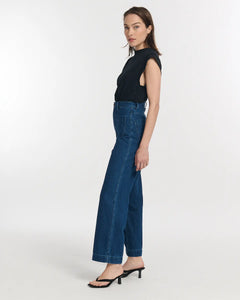 Jean en denim bleu foncé 100 % coton avec coupe large et droite, conçu pour s’adapter à toutes les morphologies féminines.