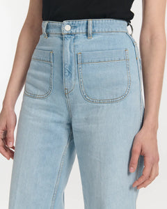 Jean femme en denim 100 % coton de couleur bleu clair, coupe droite avec taille haute et poches plaquées devant, offrant une silhouette confortable et élégante.