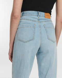 Jean droit en denim bleu clair 100 % coton avec taille haute et coupe large, s'adaptant parfaitement à toutes les morphologies féminines.