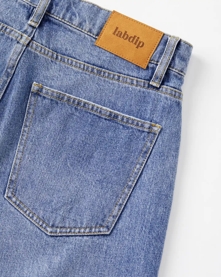 Jean en denim bleu clair 100% coton avec coupe droite, matière rigide et poche arrière classique, idéal pour femme et adapté à toutes les morphologies.