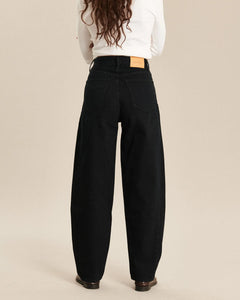 Jean femme en denim noir, coupe barrel avec taille haute, matière 100% coton offrant un tombé ample et confortable adapté à toutes les morphologies.