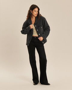Jean pour femme en denim noir charbon, coupe bootcut ajustée et légèrement évasée, avec une matière confortable et épurée qui s’adapte à toutes les morphologies.