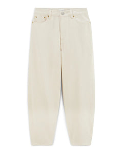 Jean ballon féminin en denim écru 100 % coton, coupe ample aux jambes larges, idéal pour un confort estival et une silhouette décontractée.