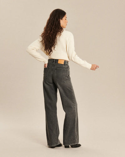 Jean femme en denim gris foncé avec coupe large et droite, matière 100 % coton offrant un tombé fluide et un confort optimal.
Porté par le mannequin de dos