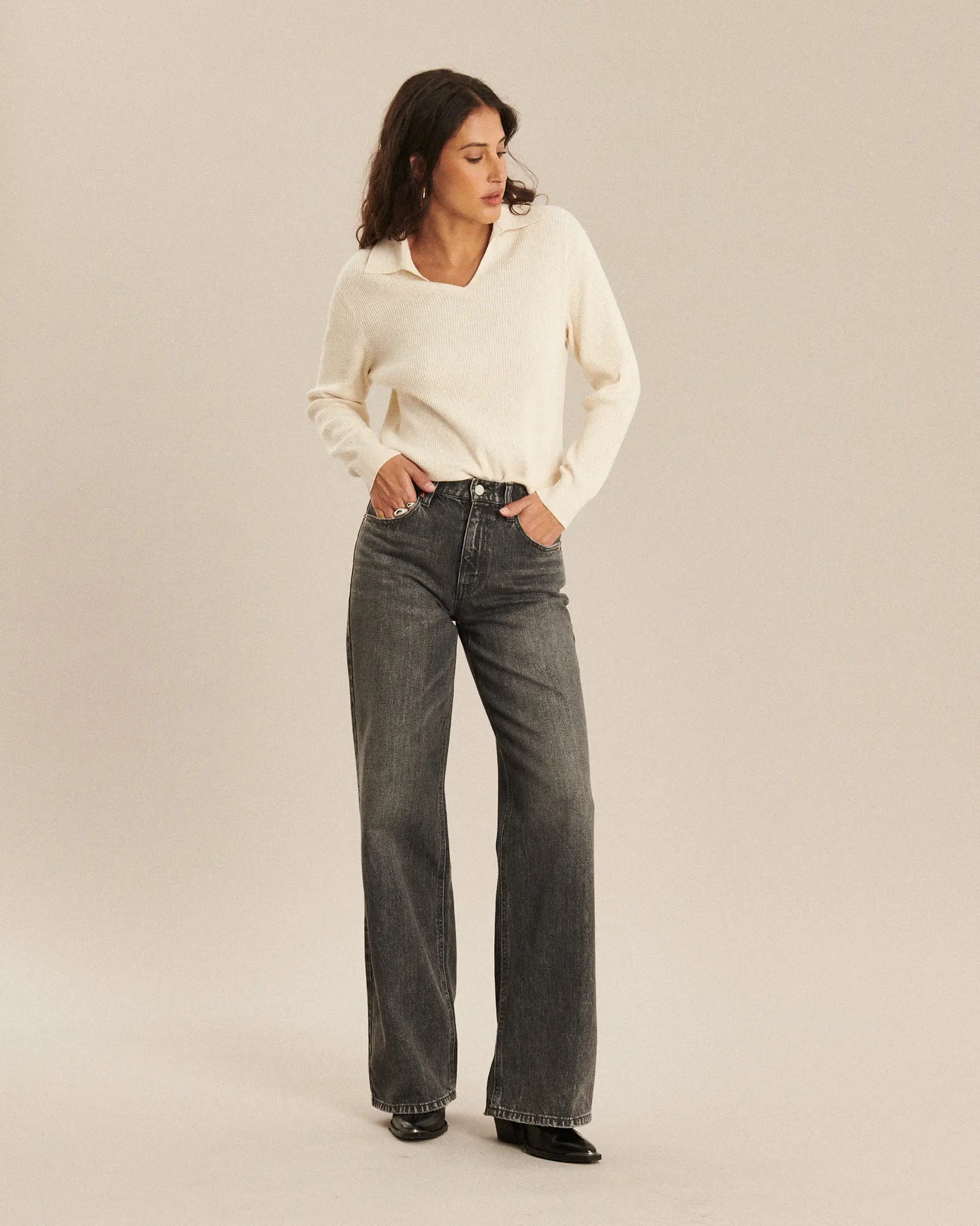 Jean flare gris dusty en denim 100% coton, coupe taille moyenne offrant un ajustement féminin et confortable, idéal pour toutes les morphologies, style automne-hiver.
Porté par le mannequin de face