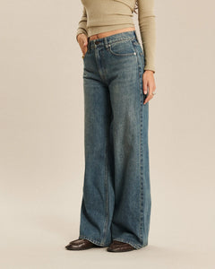Jean large en denim indigo délavé avec coupe ample et fluide, offrant un tombé élégant et confortable pour toutes les morphologies féminines.