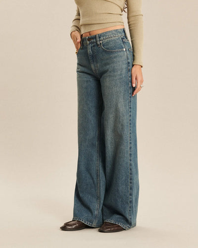 Jean large en denim indigo délavé avec coupe ample et fluide, offrant un tombé élégant et confortable pour toutes les morphologies féminines.