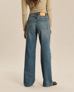 Jean femme en denim 100% coton de couleur indigo foncé avec coupe large et droite, offrant un confort optimal et une élégance décontractée.