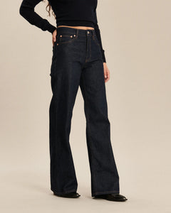 Jean femme en denim brut 100 % coton de coupe flare large, avec une matière épaisse et un ajustement confortable adapté à toutes les morphologies.