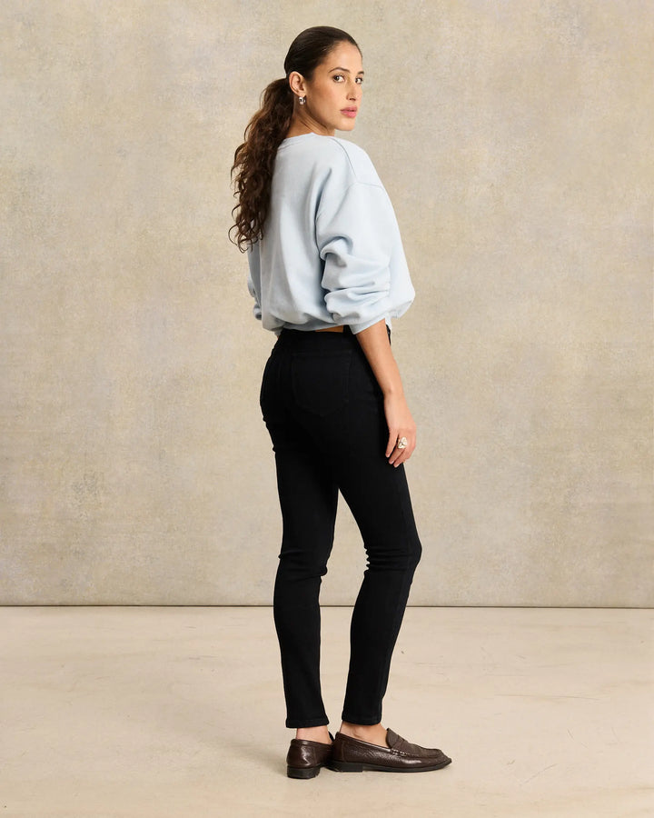 Jean slim noir en denim, coupe ajustée et matière stretch, conçu pour valoriser toutes les morphologies féminines avec un confort optimal.
porté par le mannequin de dos
