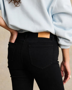 Jean slim en denim noir profond, coupe ajustée qui épouse parfaitement les formes, matière confortable et stretch, avec une étiquette en cuir discrète à l'arrière.
porté par le mannequin détail dos