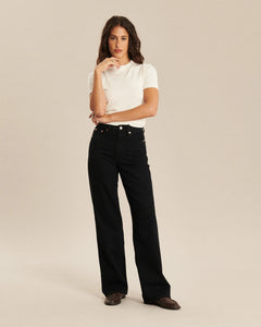 Jean droit en denim noir profond, coupe longue et large, confectionné en coton de qualité, conçu pour s’adapter parfaitement à toutes les morphologies féminines.
porté par le mannequin de face