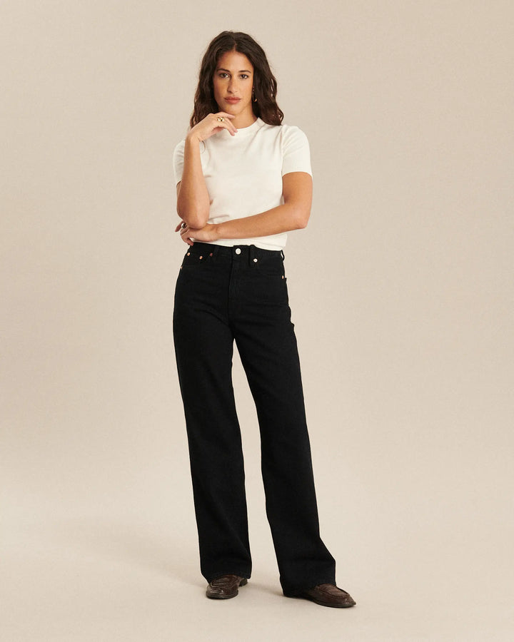 Jean droit en denim noir profond, coupe longue et large, confectionné en coton de qualité, conçu pour s’adapter parfaitement à toutes les morphologies féminines.