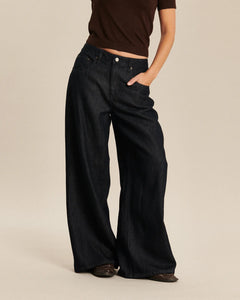 Jean femme en denim brut foncé, coupe large et fluide, matière douce en Tencel pour un confort optimal adapté à toutes les morphologies.