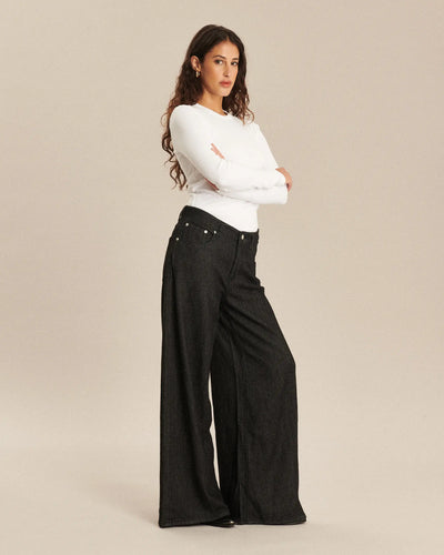 Jean femme en denim sombre, coupe large et fluide, matière souple adaptée à toutes les morphologies pour un confort optimal et un style moderne.