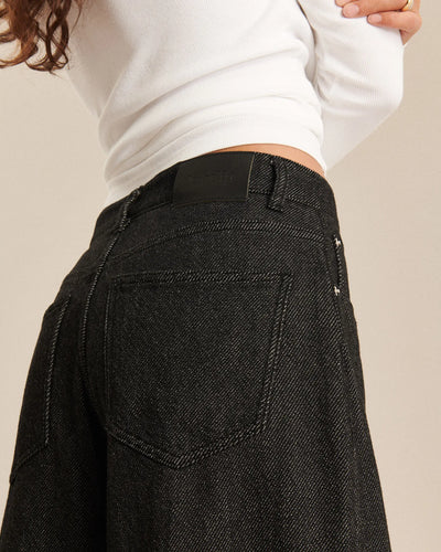 Jean pour femme en denim foncé gris anthracite, coupe large et fluide, matière 100 % coton avec texture 3D offrant un tombé léger et confortable.