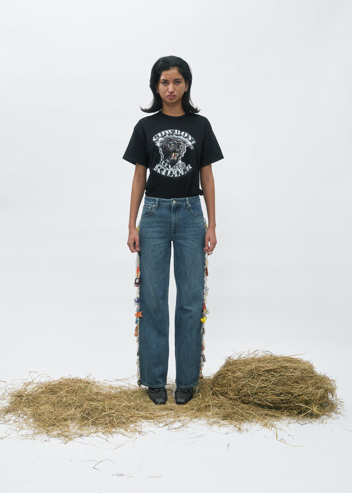 Jean en denim bleu 100% coton avec coupe droite et détails colorés sur les côtés, offrant un style décontracté et moderne pour femme.