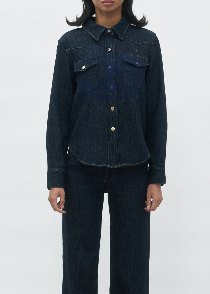 Jean droit en denim bleu foncé 100% coton, au tissu dense et légèrement rigide, avec une coupe ajustée au niveau des hanches et une jambe droite fluide adaptée à toutes les morphologies.