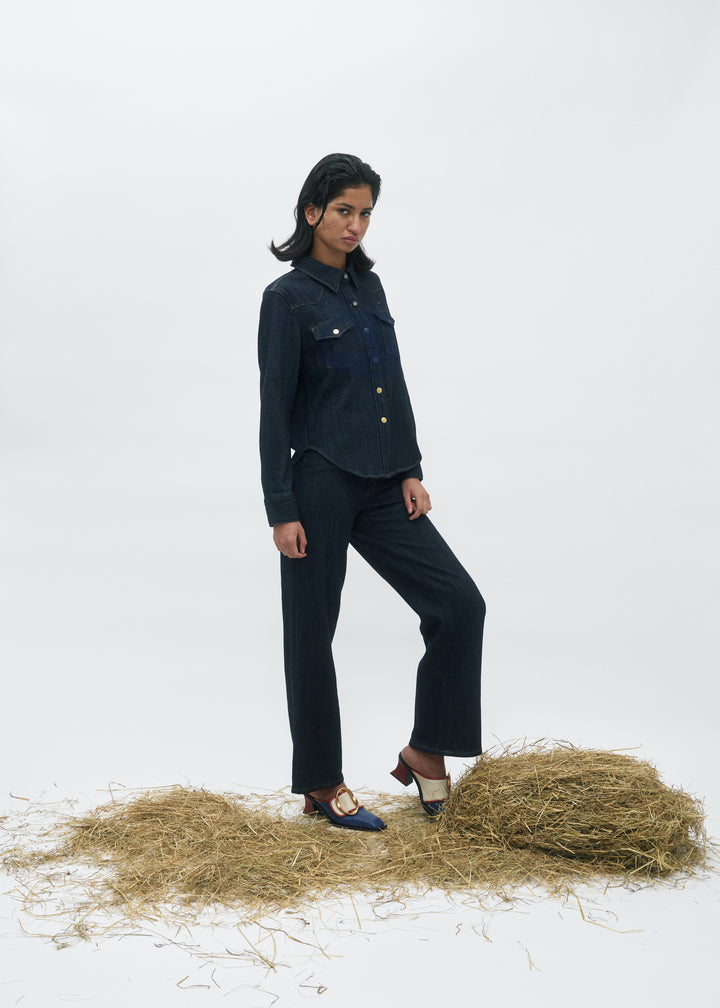Jean droit pour femme en denim bleu foncé 100% coton avec une coupe classique ajustée qui s’adapte parfaitement à toutes les morphologies.