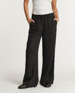 Pantalon noir fluide en tissu tencel, coupe large et droite avec taille élastiquée, confortable et adapté à toutes les morphologies féminines.