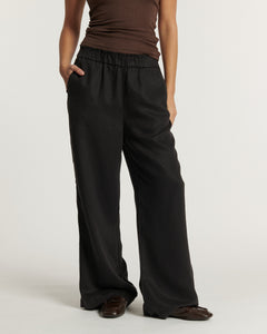 Pantalon large en tissu fluide noir avec taille élastiquée, coupe droite décontractée offrant confort et élégance, idéal pour un style femme polyvalent.